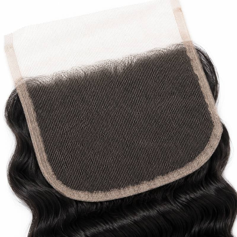 Close-up of the square lace panel and bound edge on a natural black 4x4 HD closure with deep wave hair extensions around it
