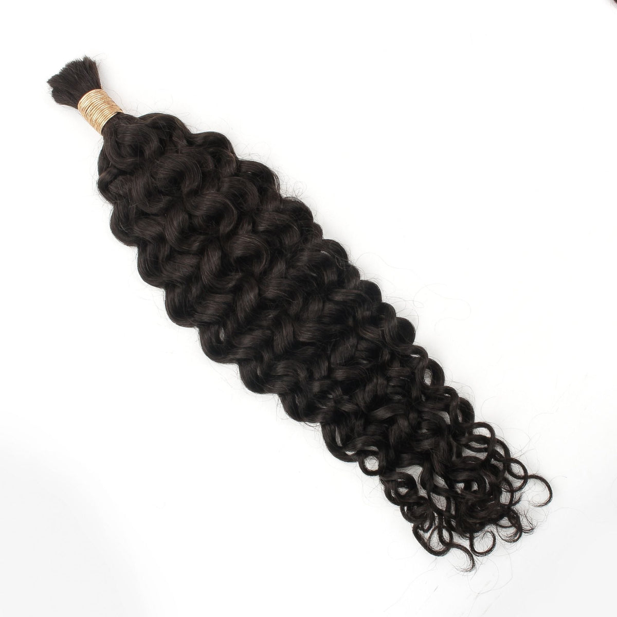 Bundle of natural black ocean wave bulk braiding hair extensions tied with a gold band and laid flat on a white background