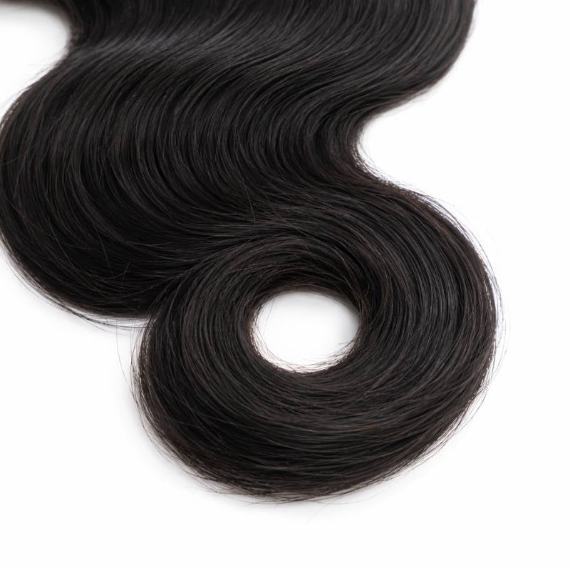 Close-up of the ring shaped curled end on natural black body wave sew-in hair extensions against a white background
