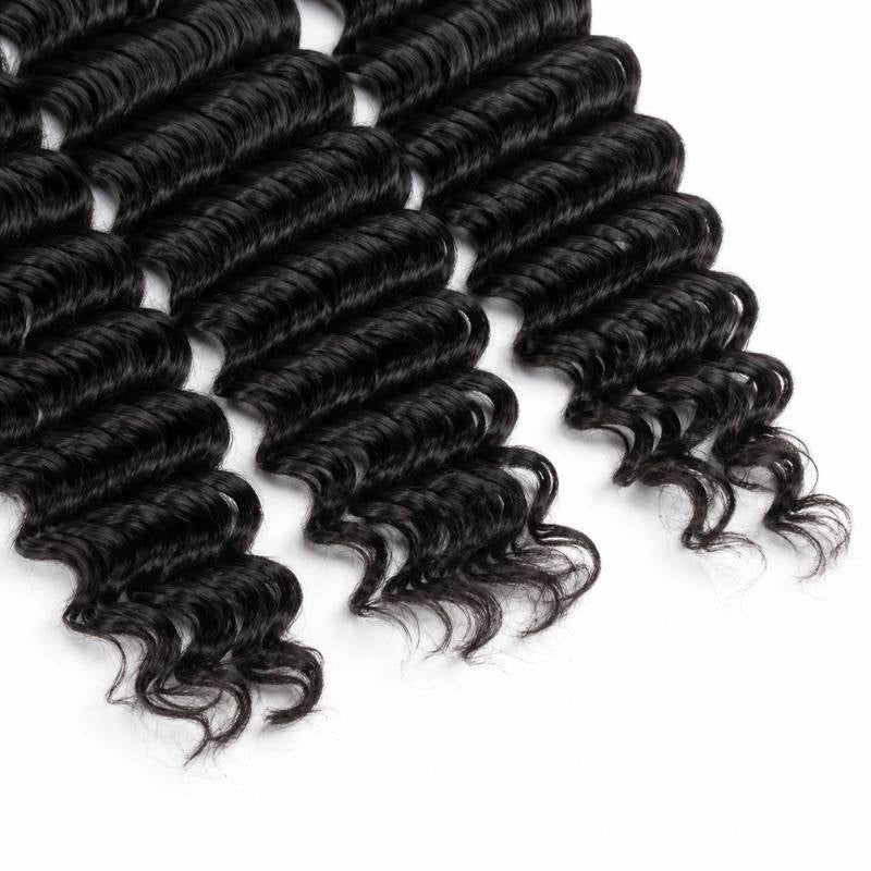 Close-up of the wave ends on three bundles of natural black deep wave sew-in hair extensions fanned out on a white background