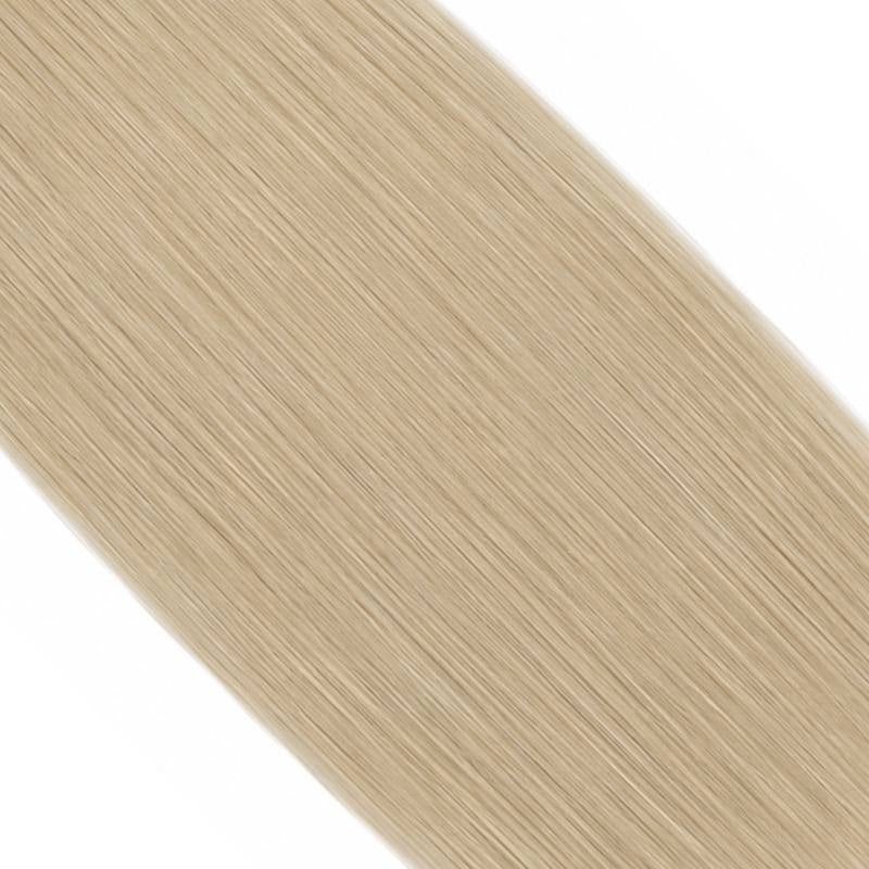 Full frame macro of blonde straight sew-in hair extensions with the strands running diagonally across the frame