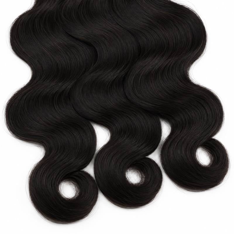 Close-up of the ends of three bundles of natural black body wave sew-in hair extensions curling into loose rings on a white background