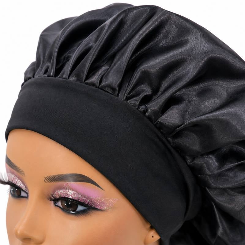 Close-up of the black silk bonnet showing the stitched elastic band and gathered edge that hold it in place over hair extensions