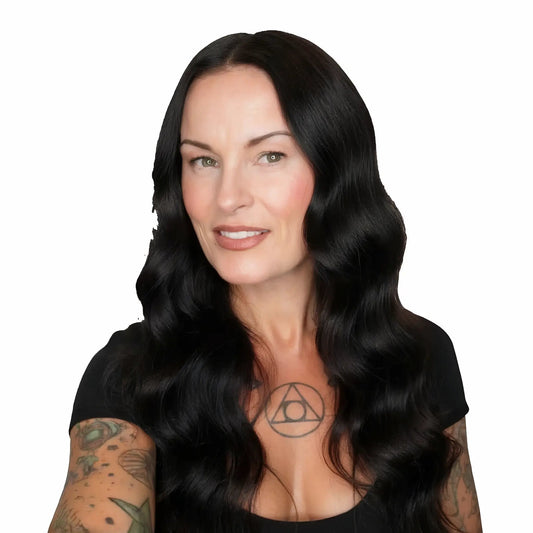Woman with long black hair and tattoos on a white background