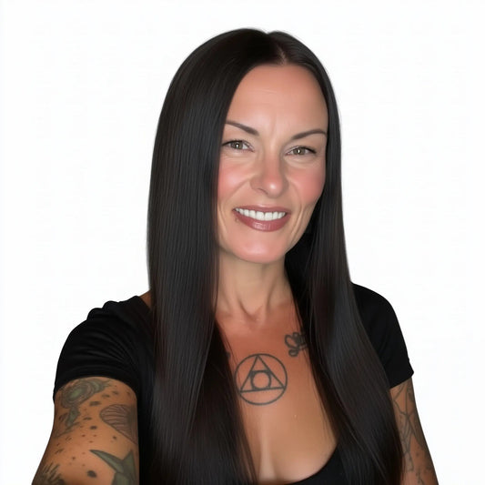 Woman with long dark hair and tattoos on arms and chest against a white background