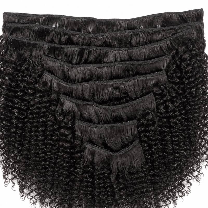 Full set of natural black afro kinky curly clip-in hair extensions fanned out to show the machine sewn weft tops of each piece