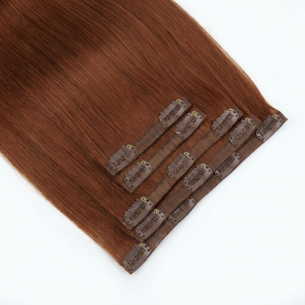 Copper straight clip-in hair extensions fanned at an angle so the matching snap clips on each seamless weft are visible