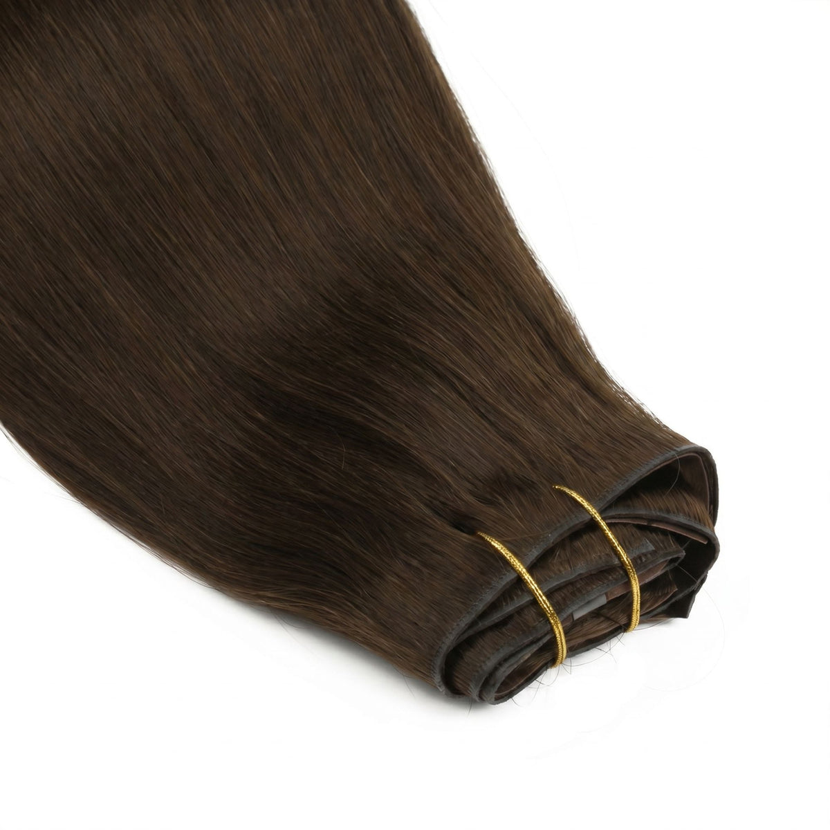 Close-up of the folded weft ends on dark brown straight clip-in hair extensions bound with two gold thread ties