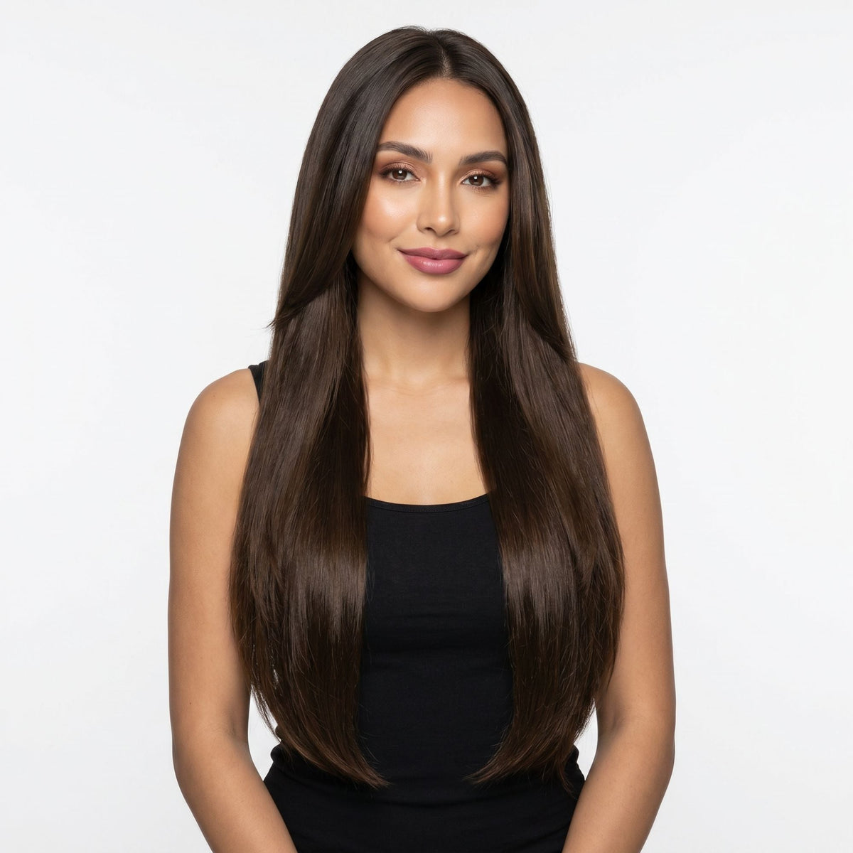 Model facing forward wearing long straight dark brown clip-in hair extensions parted in the centre against a white studio backdrop