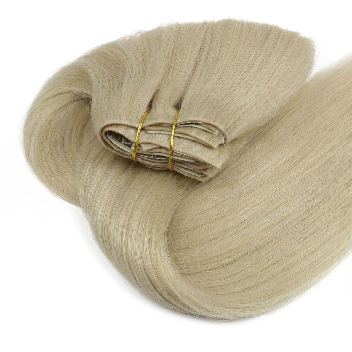 Honey blonde straight clip-in hair extensions coiled into a loop with the folded wefts bound by two gold thread ties