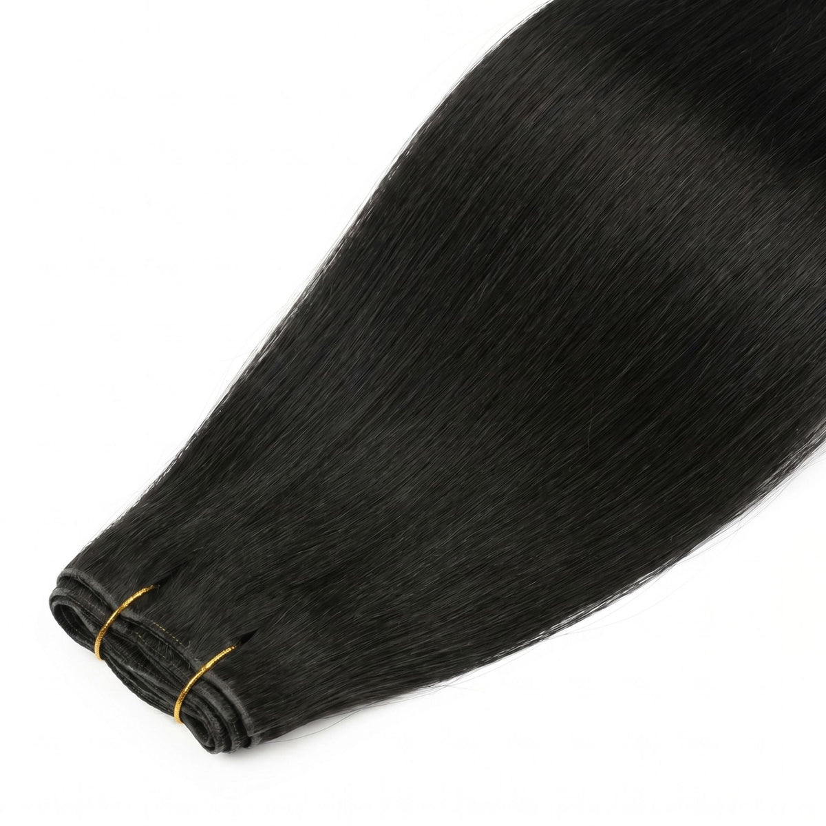 Close view of the folded weft ends on jet black straight clip-in hair extensions held together by a gold thread tie
