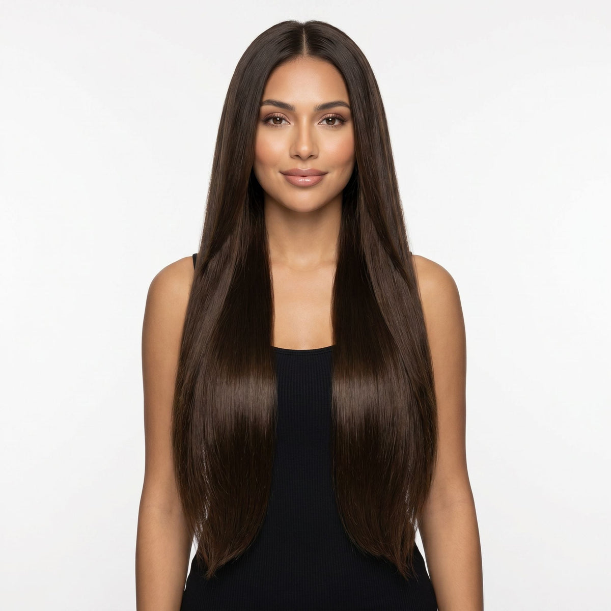 Model facing forward wearing long straight dark brown clip-in hair extensions parted in the centre against a white studio backdrop