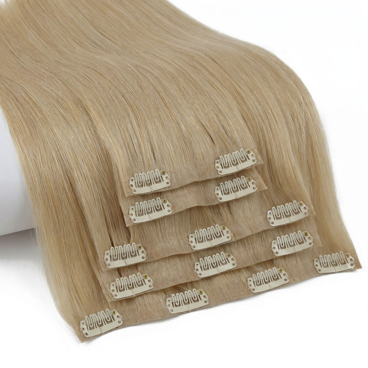 Honey blonde straight clip-in hair extensions fanned at an angle so the clips on every seamless weft in the set are visible