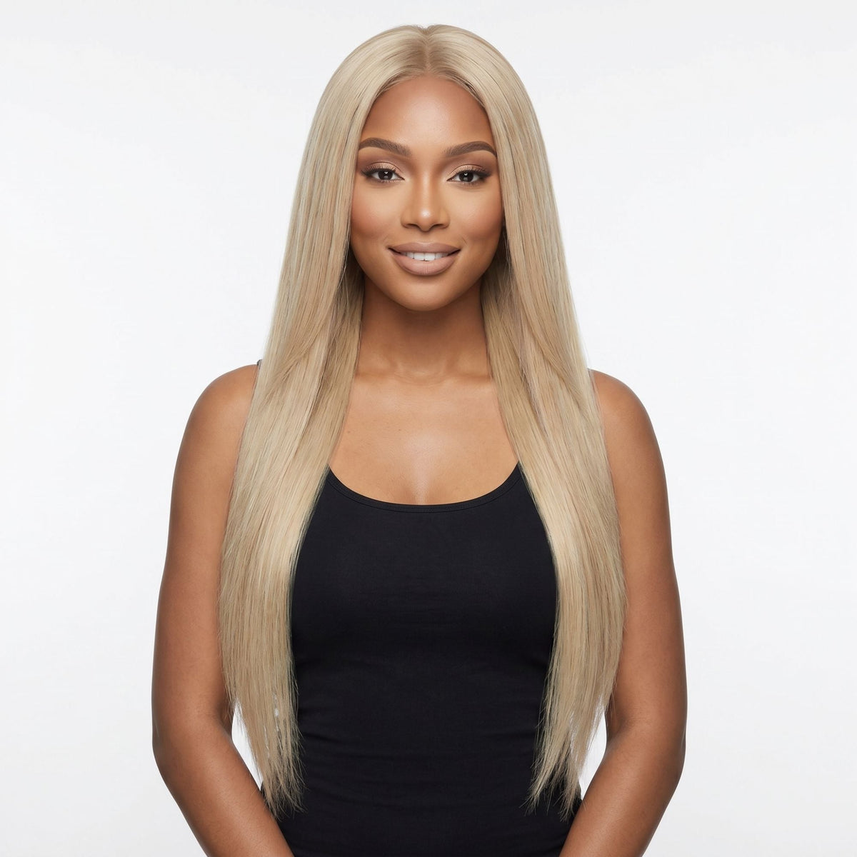 Model facing forward wearing long straight honey blonde clip-in hair extensions parted in the centre against a white studio backdrop