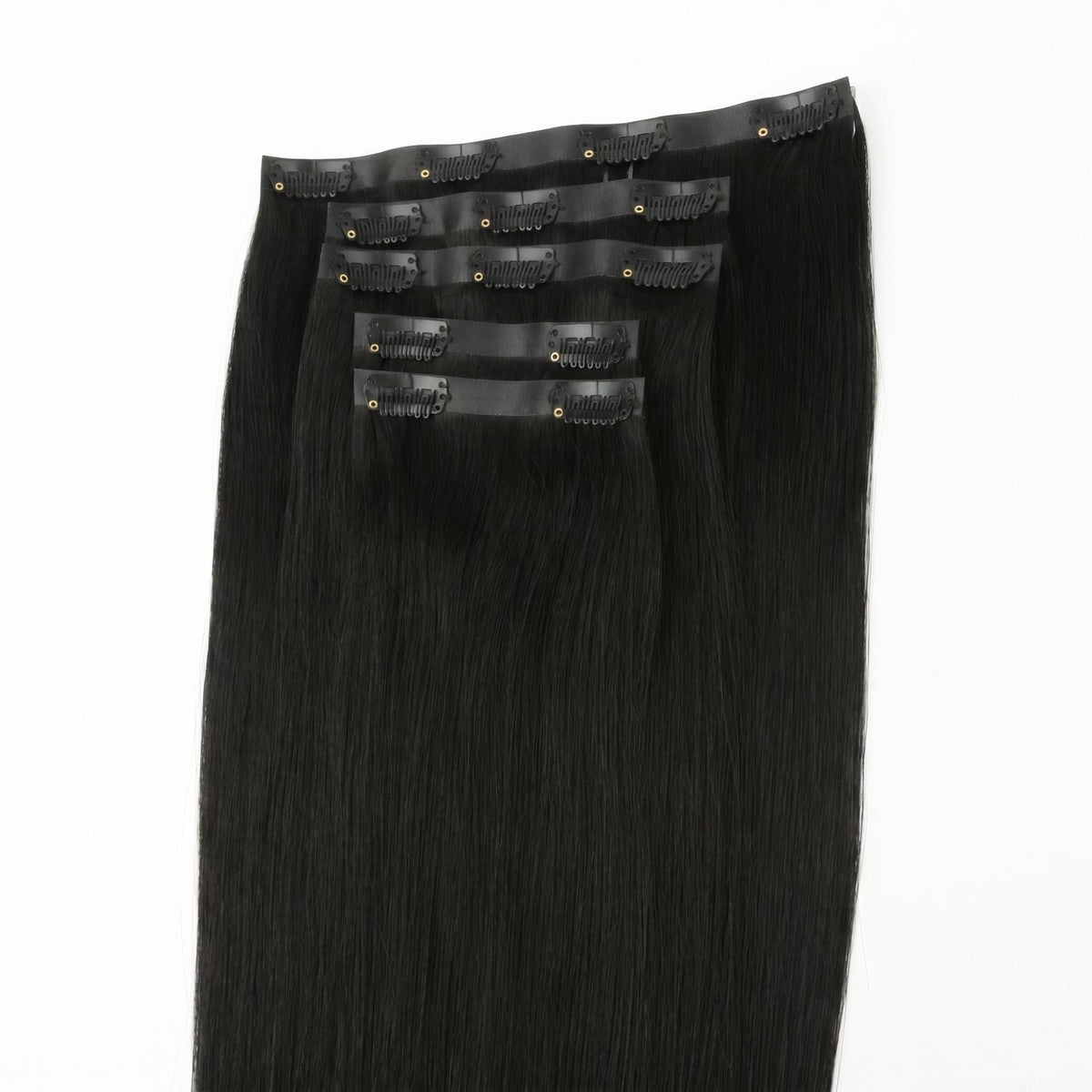 Full set of jet black straight clip-in hair extensions laid flat with the seamless bands and black snap clips facing up