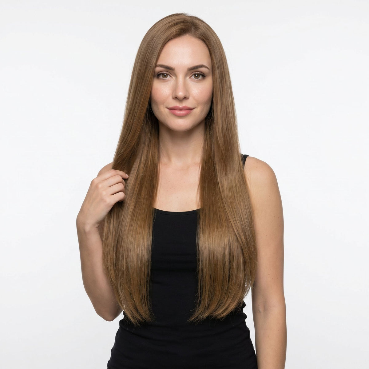 Model holding a section of her long straight chestnut brown clip-in hair extensions against a white studio backdrop