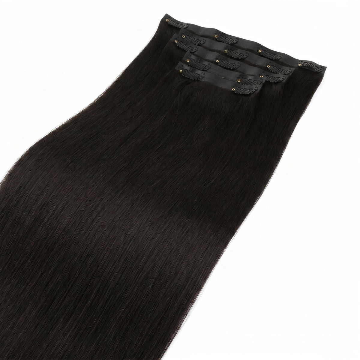Off black straight clip-in hair extensions stacked so the clipped seamless bands sit together at the top of the frame