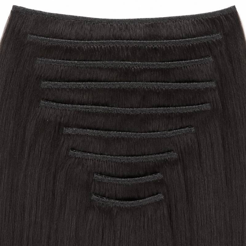 Close-up of the stitched weft tops on natural black yaki straight clip-in hair extensions, showing the graduated widths within the set