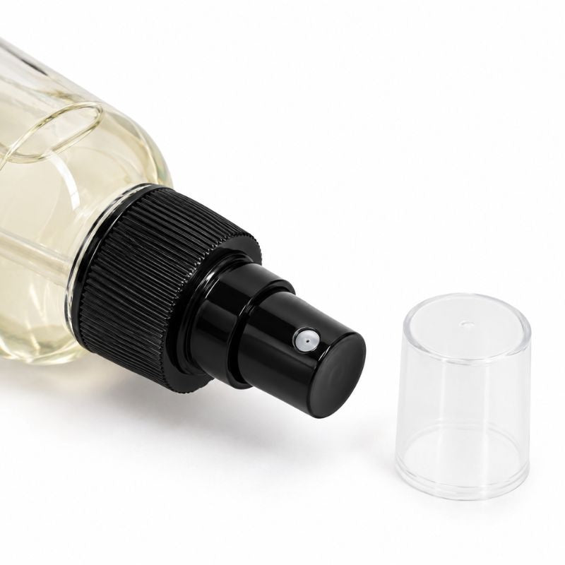 Close-up of the black spray nozzle and clear cap on the citrus adhesive remover bottle used with lace wigs and hair extensions