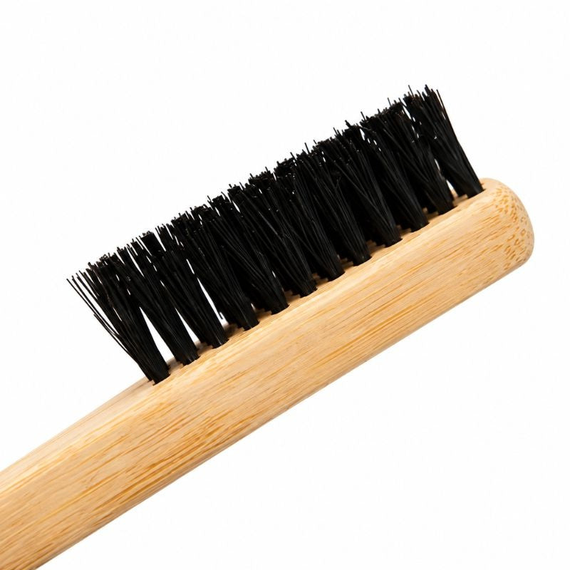 Close-up of the black bristle head and light wooden handle on the 3-in-1 edge brush used for styling edges with hair extensions