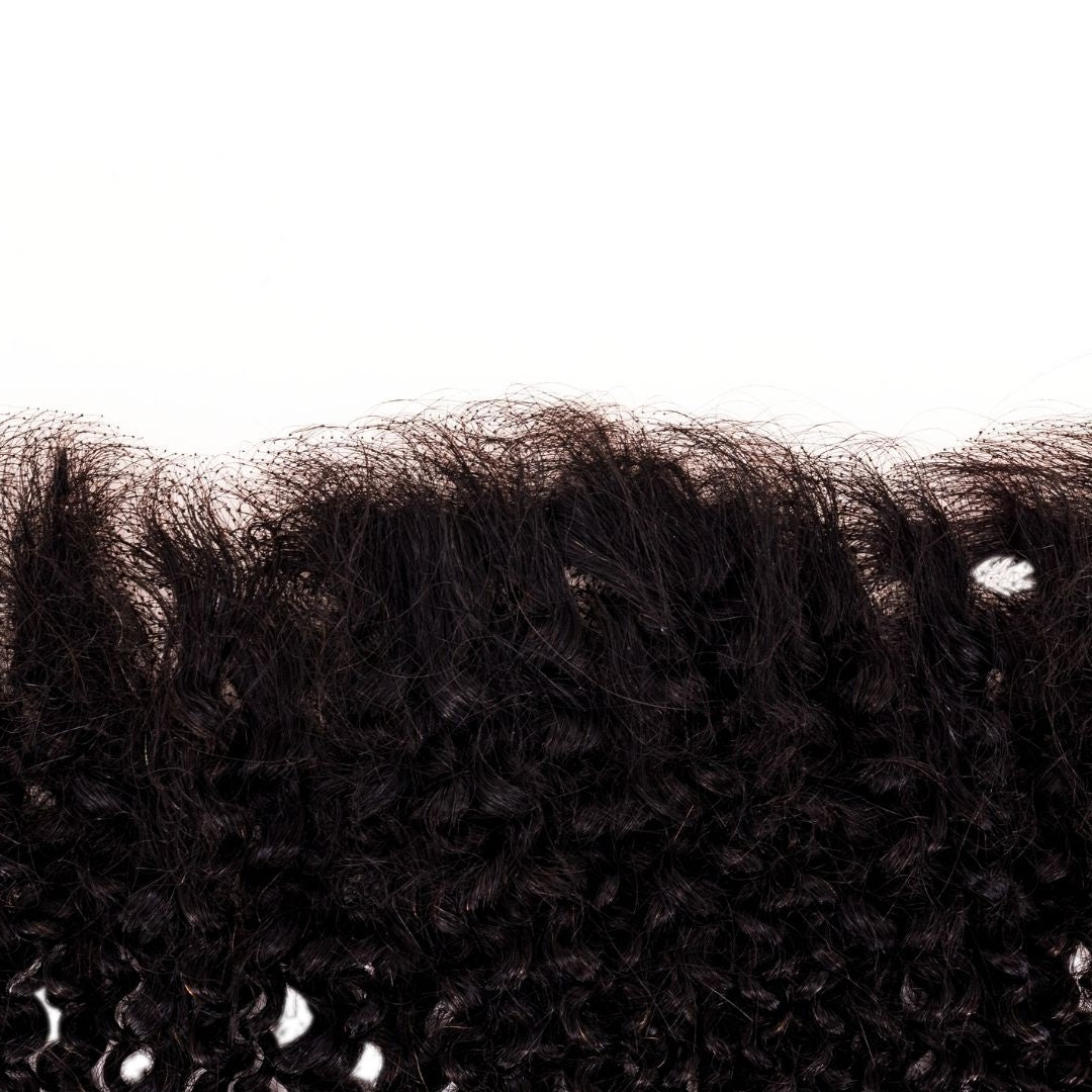 Macro view of the knots and fine baby hairs along the transparent lace hairline of natural black afro kinky curly hair extensions