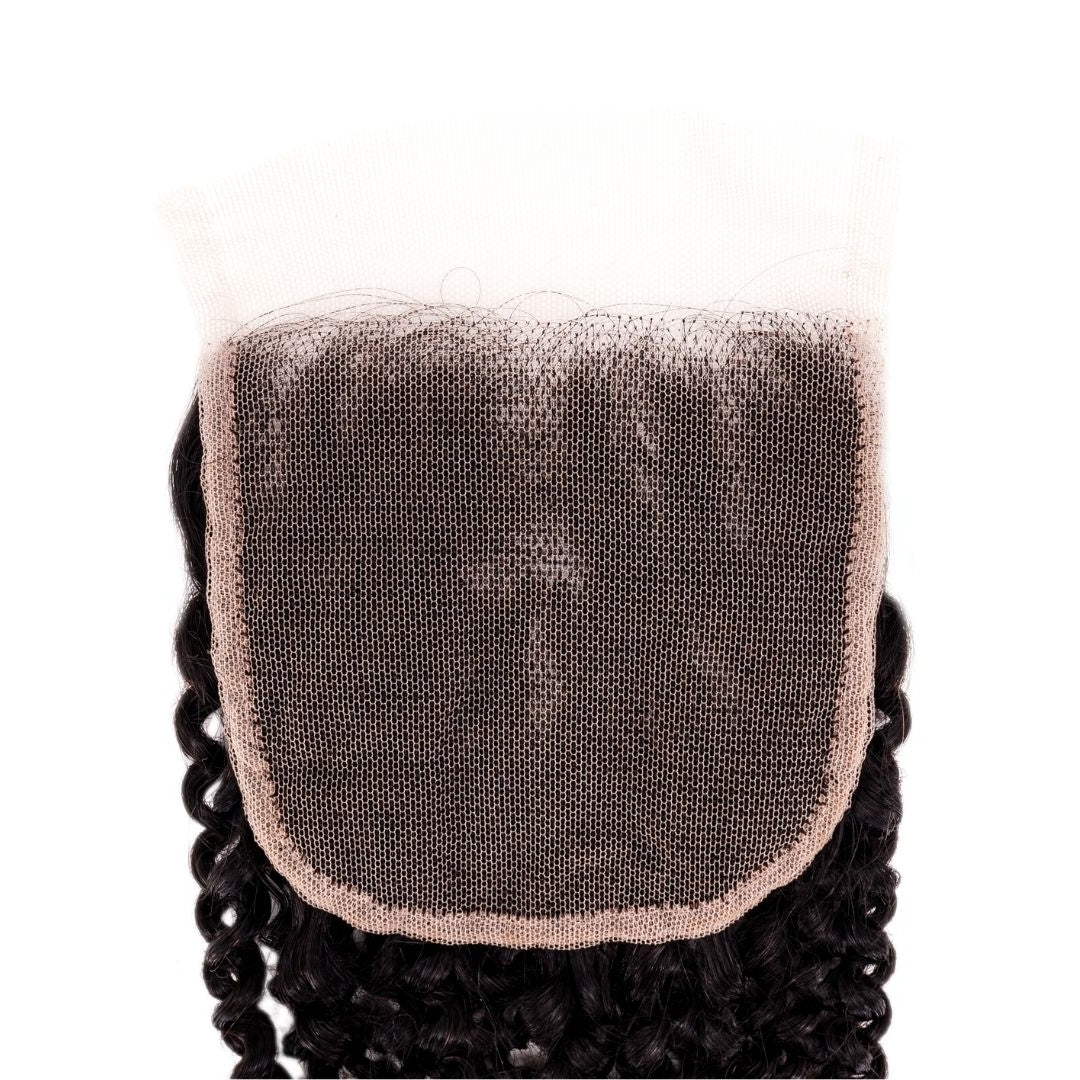Close-up of the square transparent lace panel on a white background with natural black curly hair extensions knotted around its border