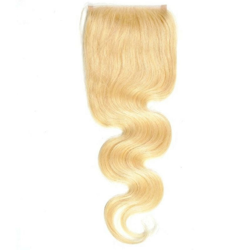 Blonde body wave hair extensions on a transparent lace closure shown hanging with the wave curving through the lengths