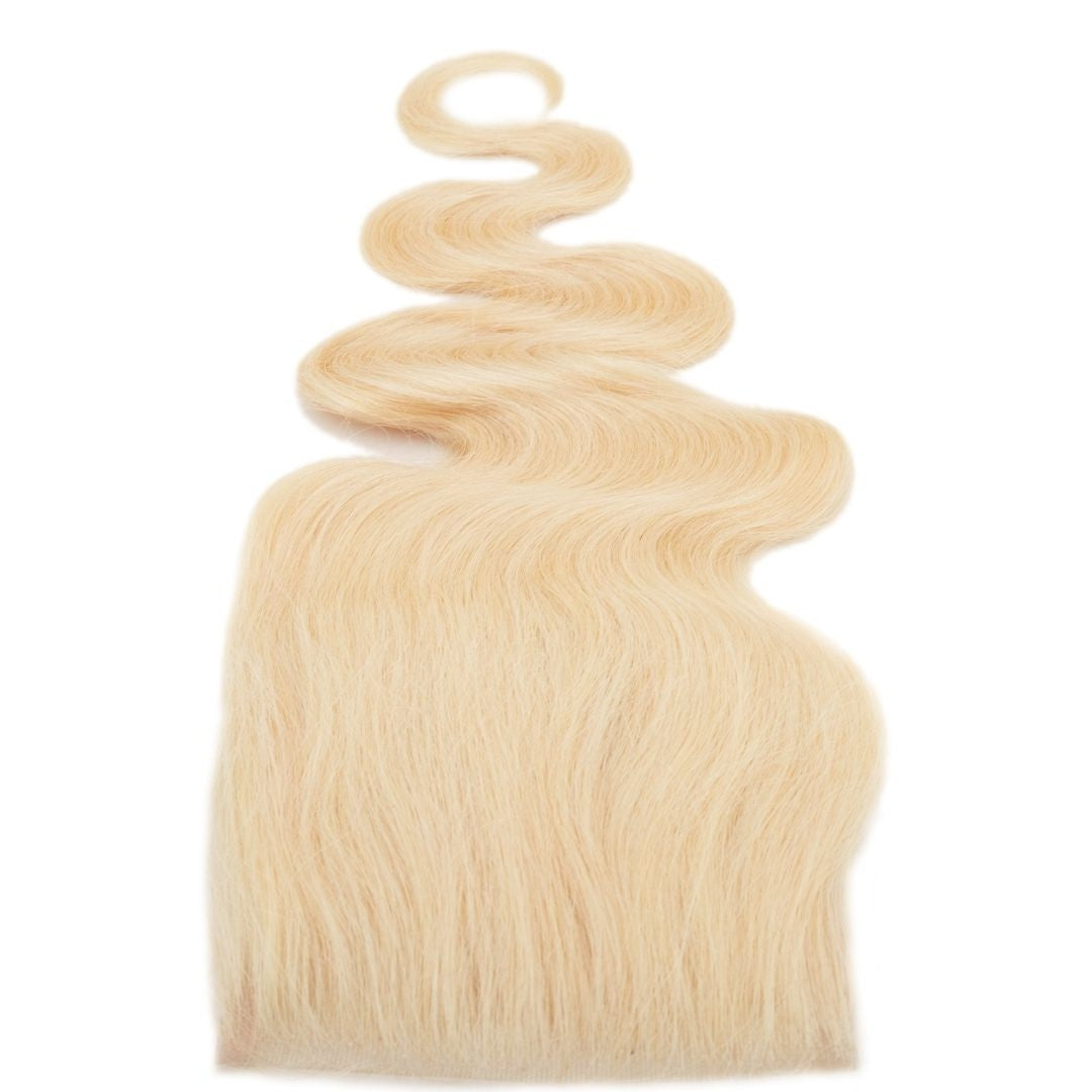 Blonde body wave hair extensions arranged with the ends fanned wide and a single wave curling above, shown on a white background