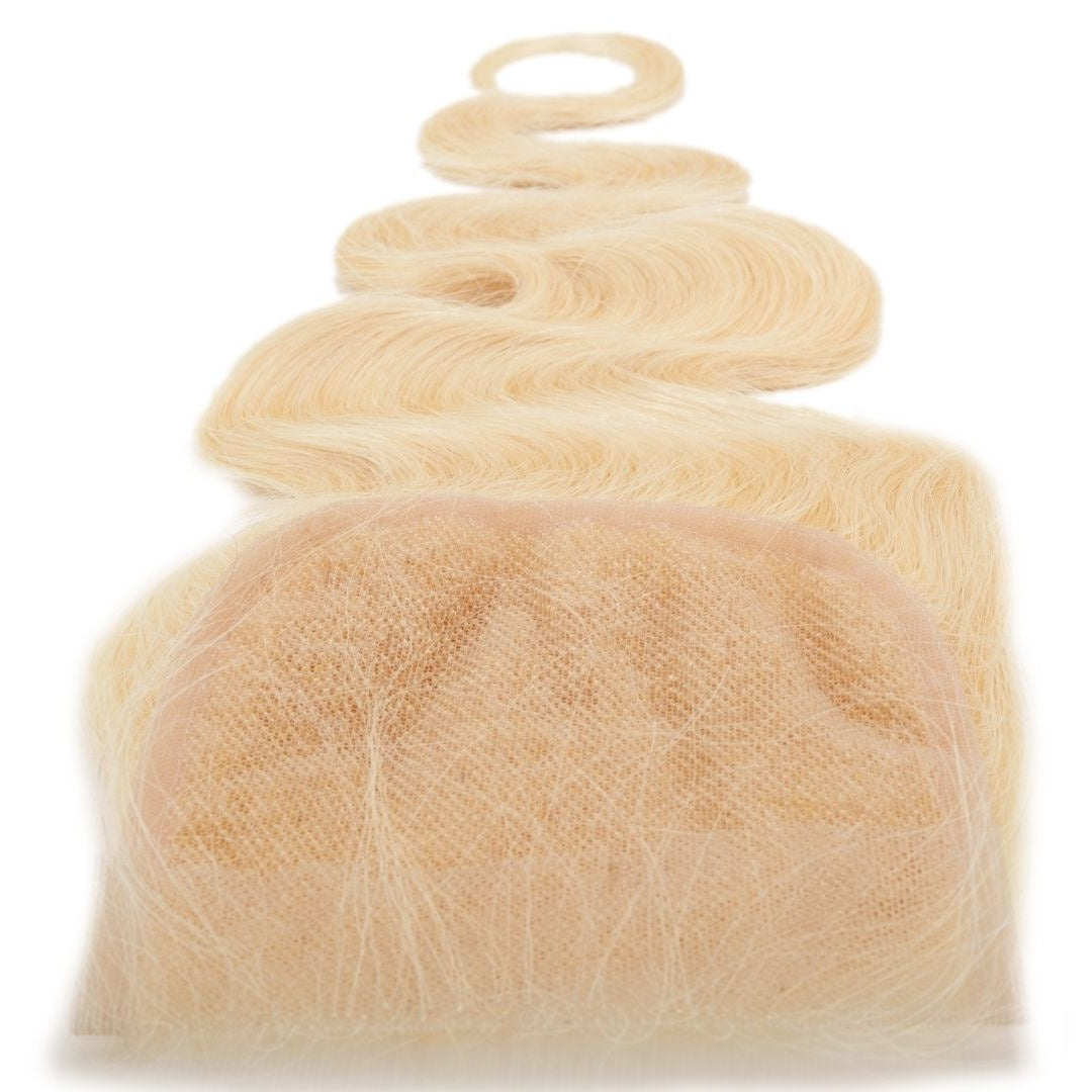 Close-up of the transparent lace panel on a blonde body wave hair extensions closure against a white background with the wave curling above
