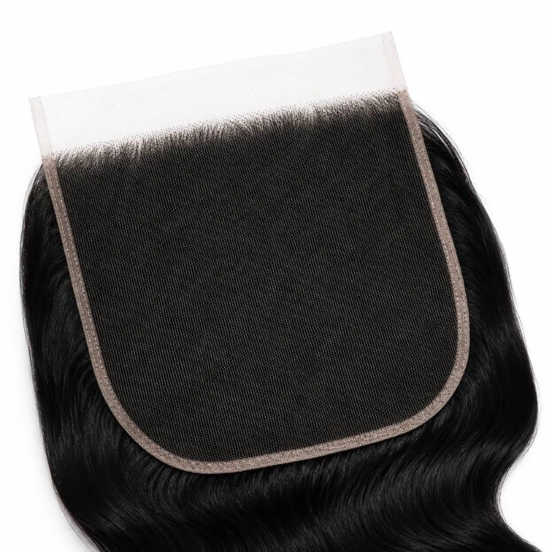 Close-up of the large square HD lace closure panel and knotted hairline on jet black body wave hair extensions