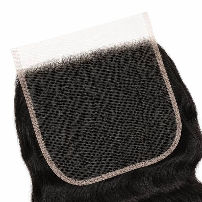Close-up of the large square HD lace closure panel with natural black body wave hair extensions knotted at the hairline