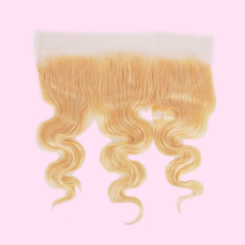 Blonde 613 body wave transparent frontal photographed on a pink background showing the lace band above the waved hair extensions