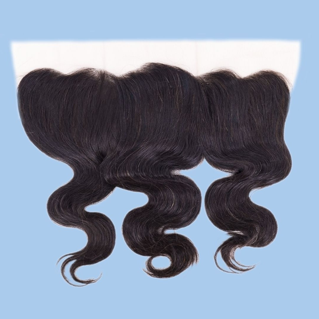 Natural black body wave transparent frontal laid flat on a blue background with the lace band across the top and waved hair extensions below