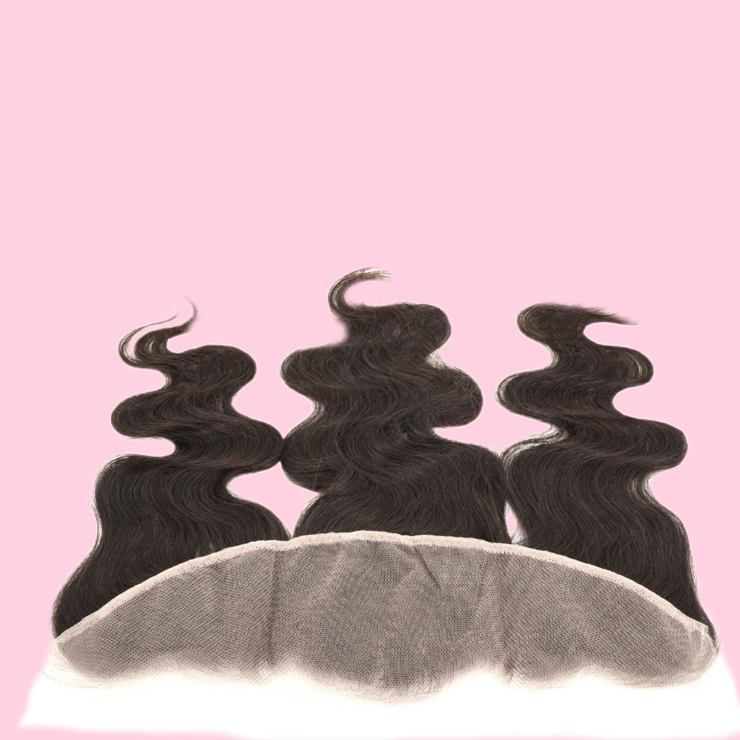 Natural black body wave transparent frontal on pink with the lace panel facing the camera and three waved sections of hair extensions behind it