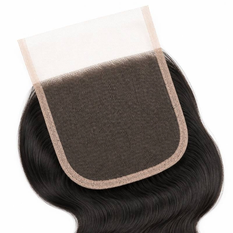 Close-up of the square lace panel and its bound edge on a natural black 4x4 HD closure with body wave hair extensions around it
