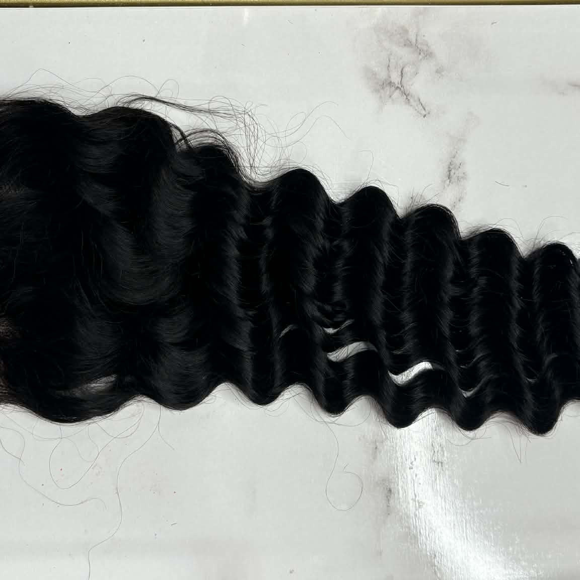 Close-up of 16 inch Brazilian deep wave 4x4 transparent closure hair extension showing lace grid detail and deep wave curl pattern