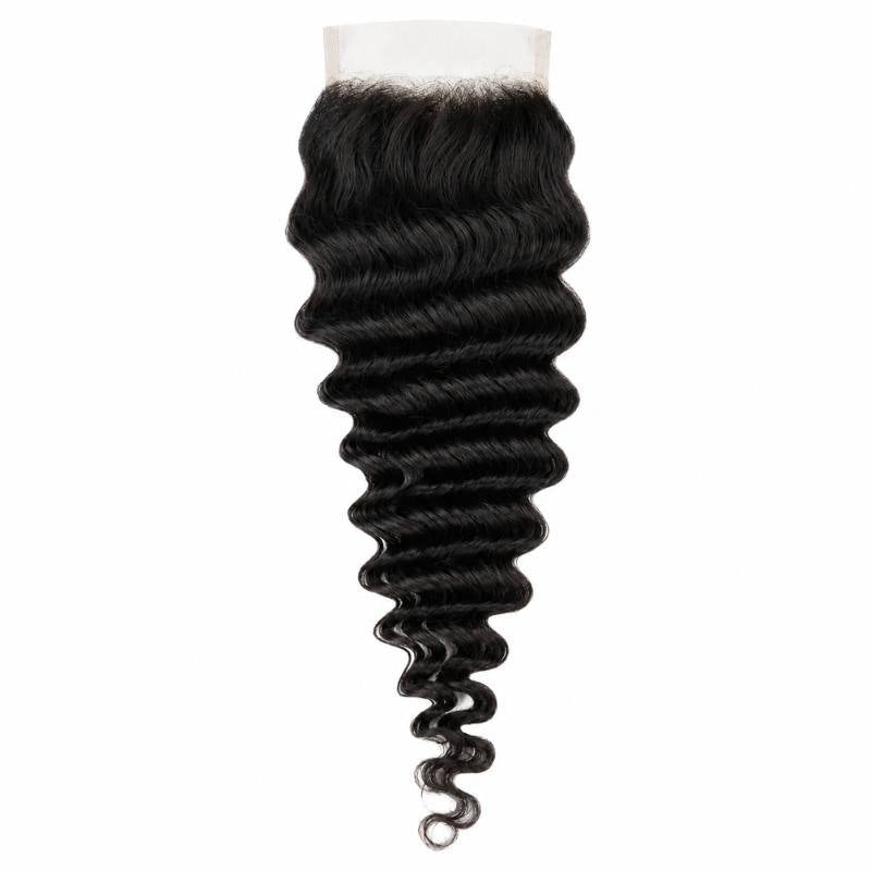 Natural black 4x4 transparent closure laid flat on white with the lace panel at the top and deep wave running the full length of the hair extensions