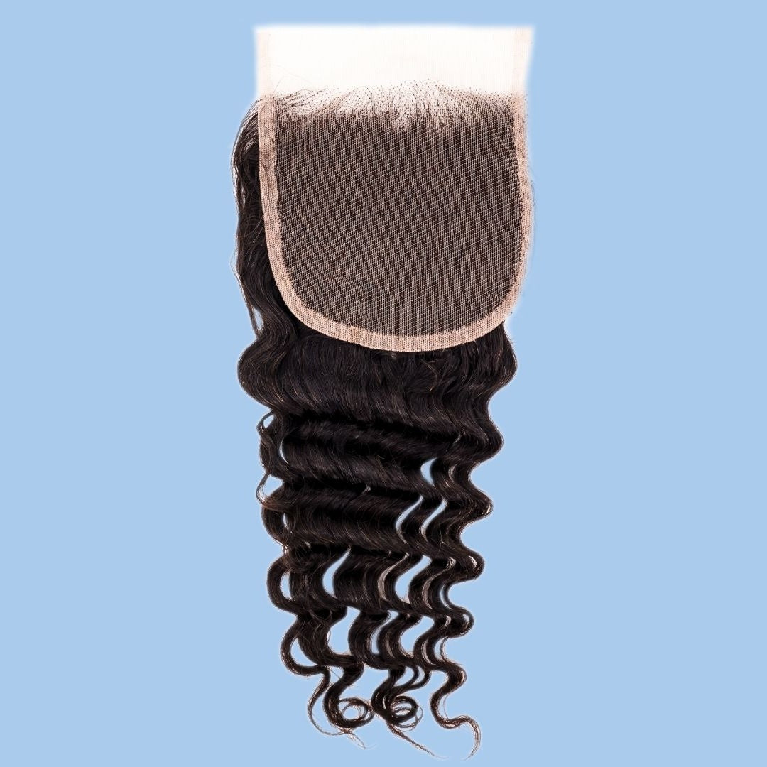 Natural black 4x4 transparent closure lace side up on a blue background with the square lace panel above the deep wave hair extensions
