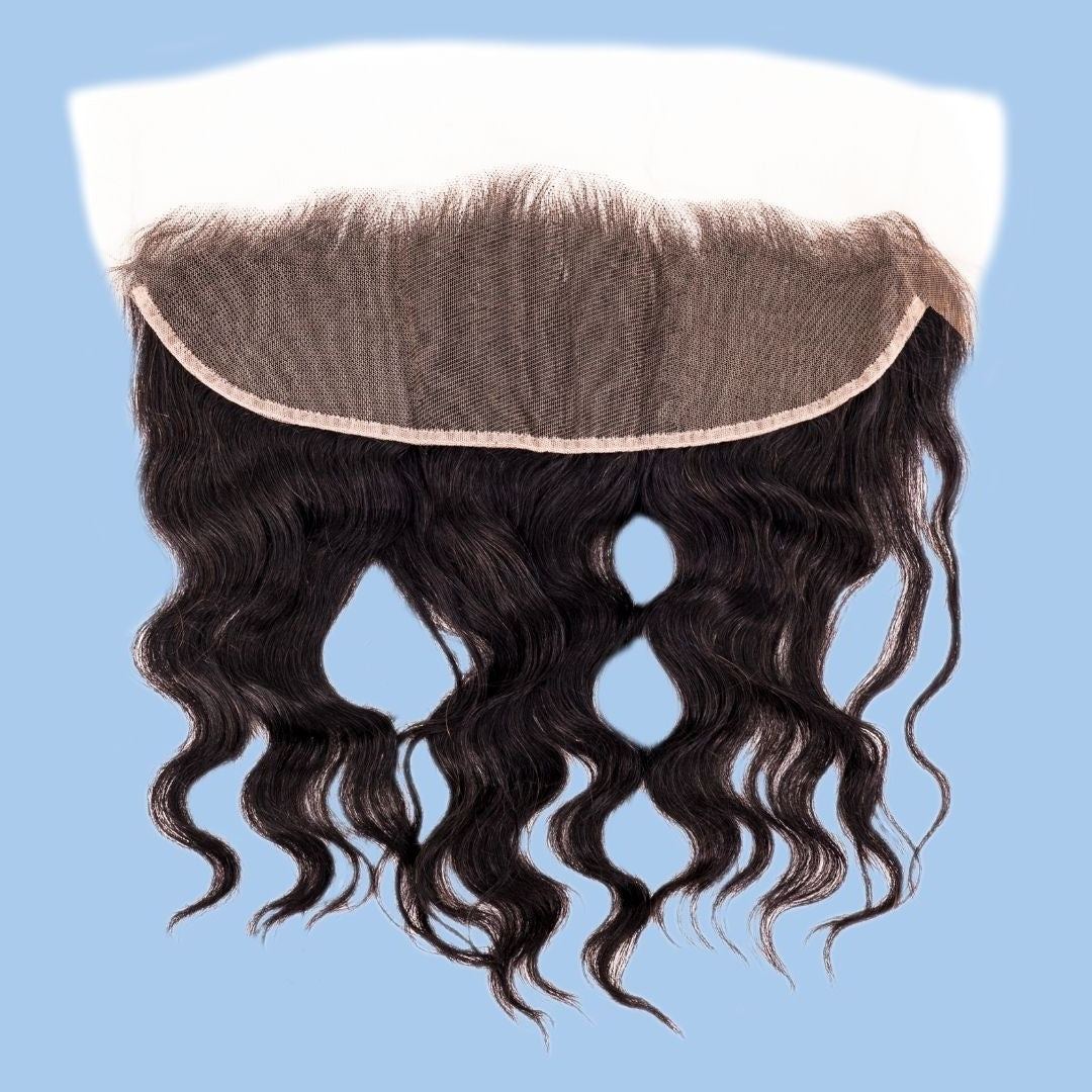 Underside of the transparent frontal folded back to show the lace mesh above natural black loose wave hair extensions on a blue background