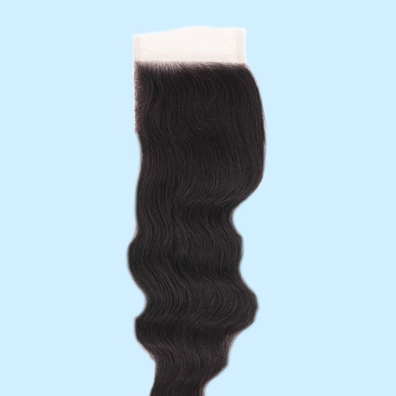 4x4 HD closure hung against a light blue backdrop showing the loose wave pattern of the natural black hair extensions