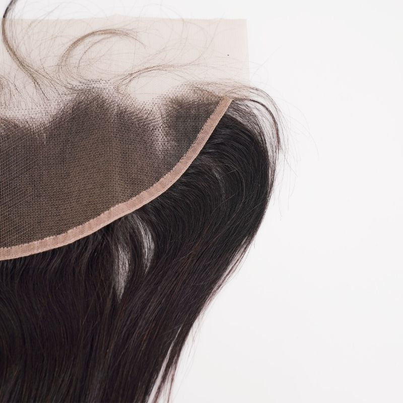 Underside of the transparent frontal showing the lace panel and its bound edge above straight natural black hair extensions