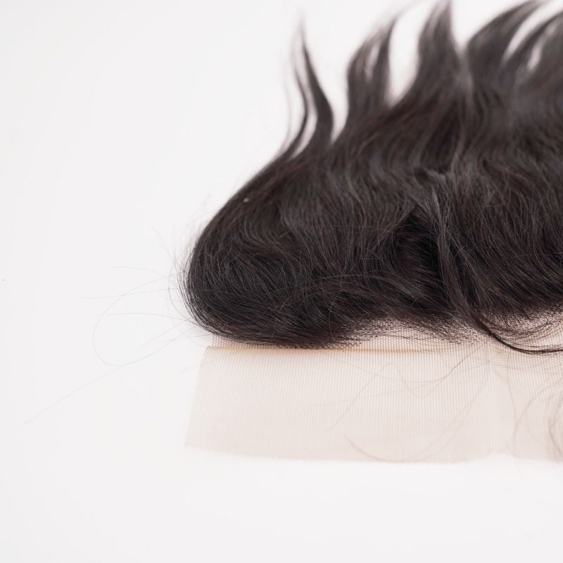 Close-up of the transparent lace strip along the frontal hairline with loose baby hairs on straight natural black hair extensions