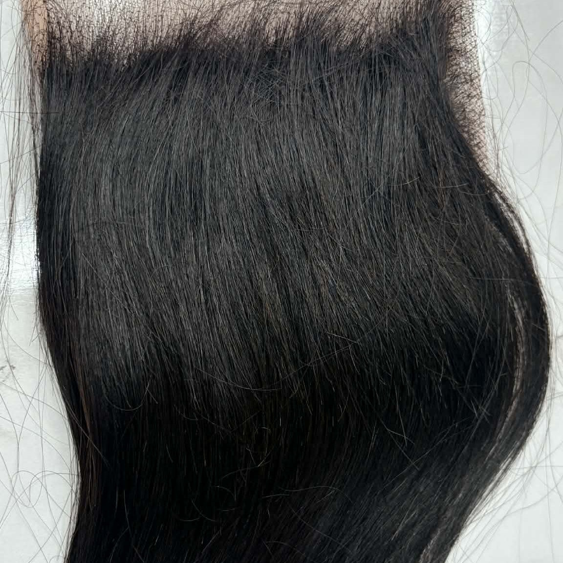 14 inch Brazilian straight 5x5 HD closure hair extension flat lay on white surface showing lace parting area and sleek straight hair