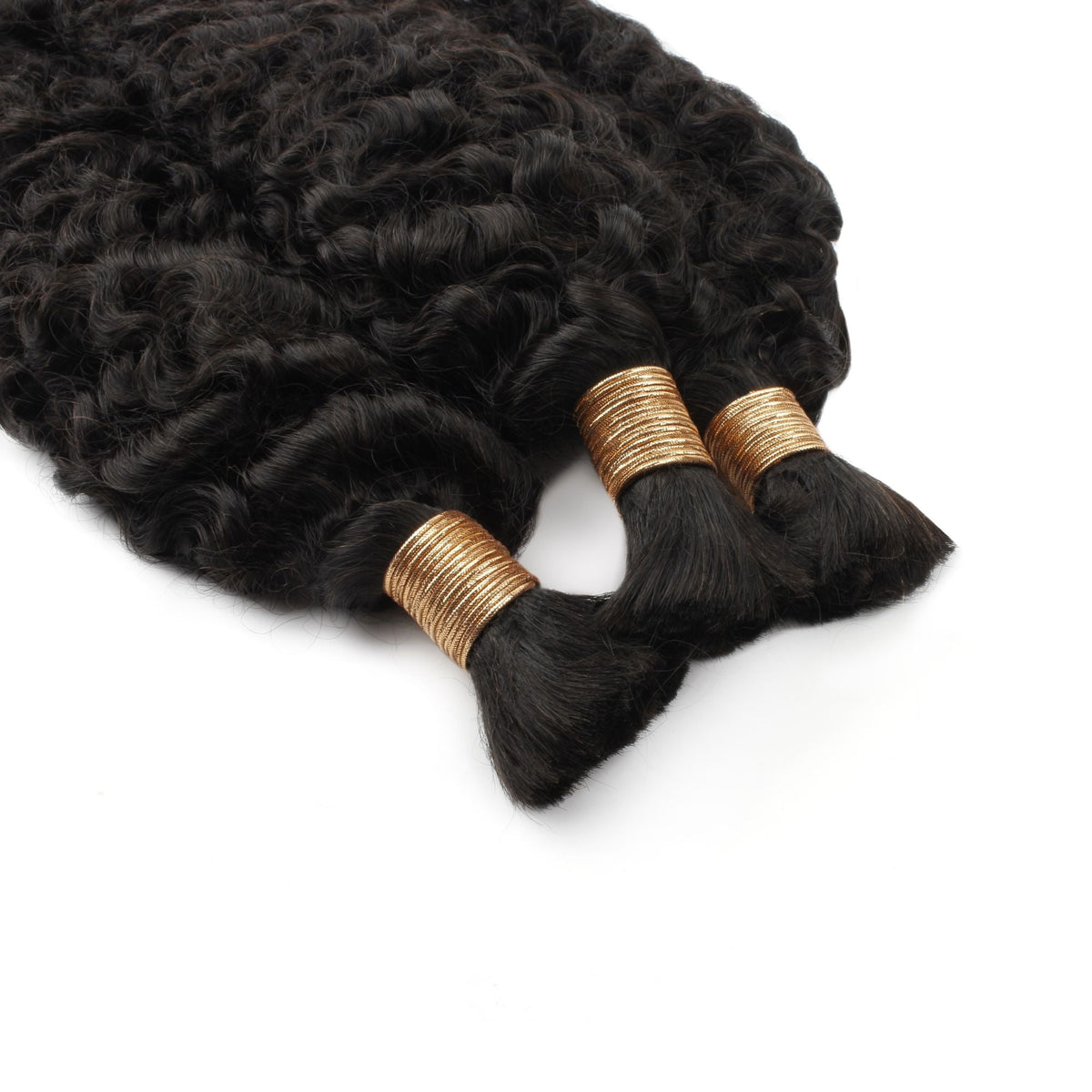 Three bundles of natural black curly bulk braiding hair extensions bound with gold thread ties on a white surface