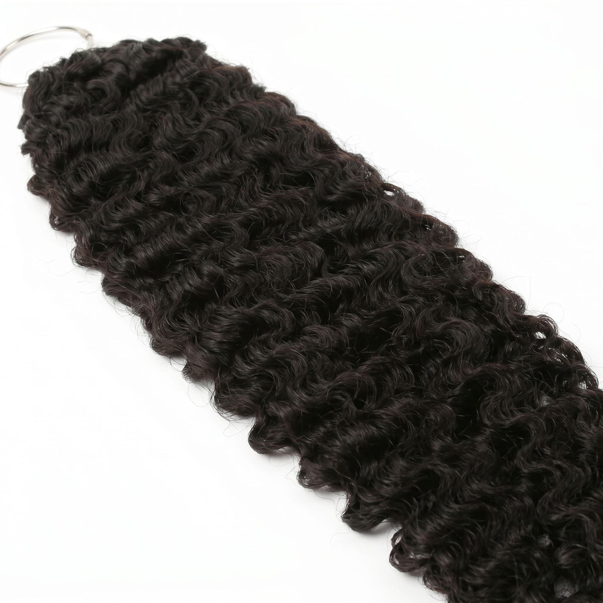 Close crop of the curl texture on natural black curly crochet hair extensions with the metal ring visible at the bound end