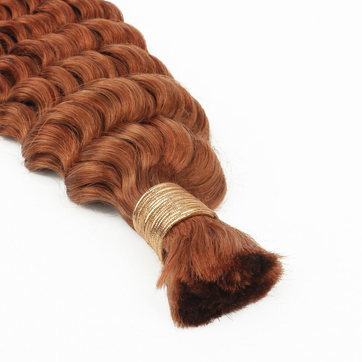 Close-up of the gold thread wrapped tip on a bundle of copper deep wave bulk braiding hair extensions showing the cut ends
