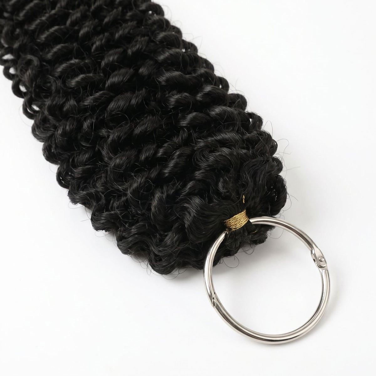 Macro view of the split ring and gold thread binding at the loop of natural black kinky curly feather crochet hair extensions