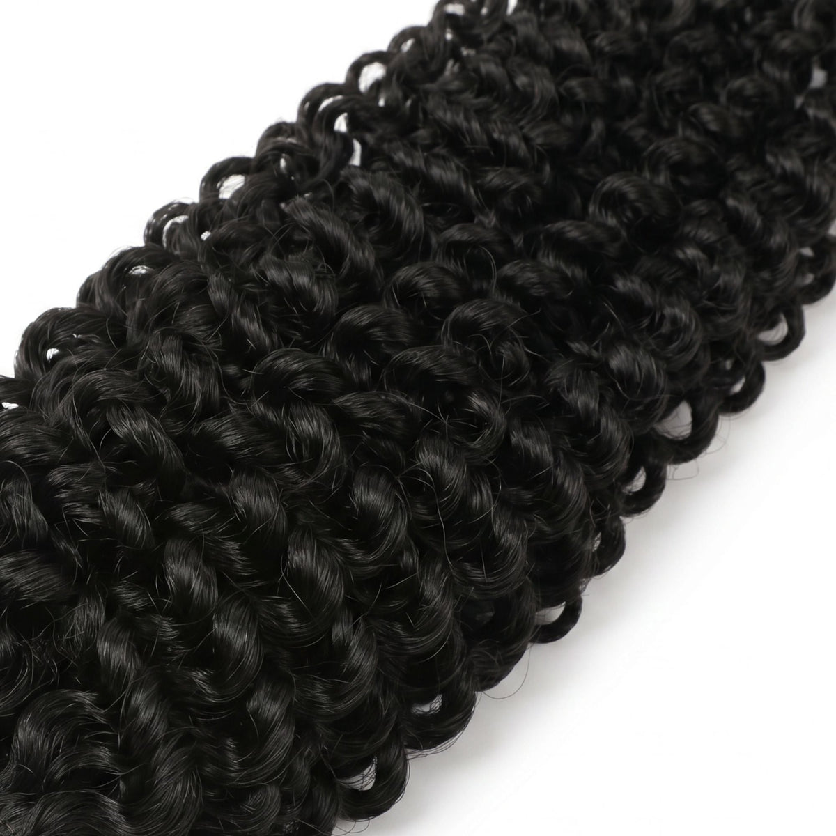 Close-up of the coiled curl pattern on natural black kinky curly feather crochet hair extensions laid on a white surface