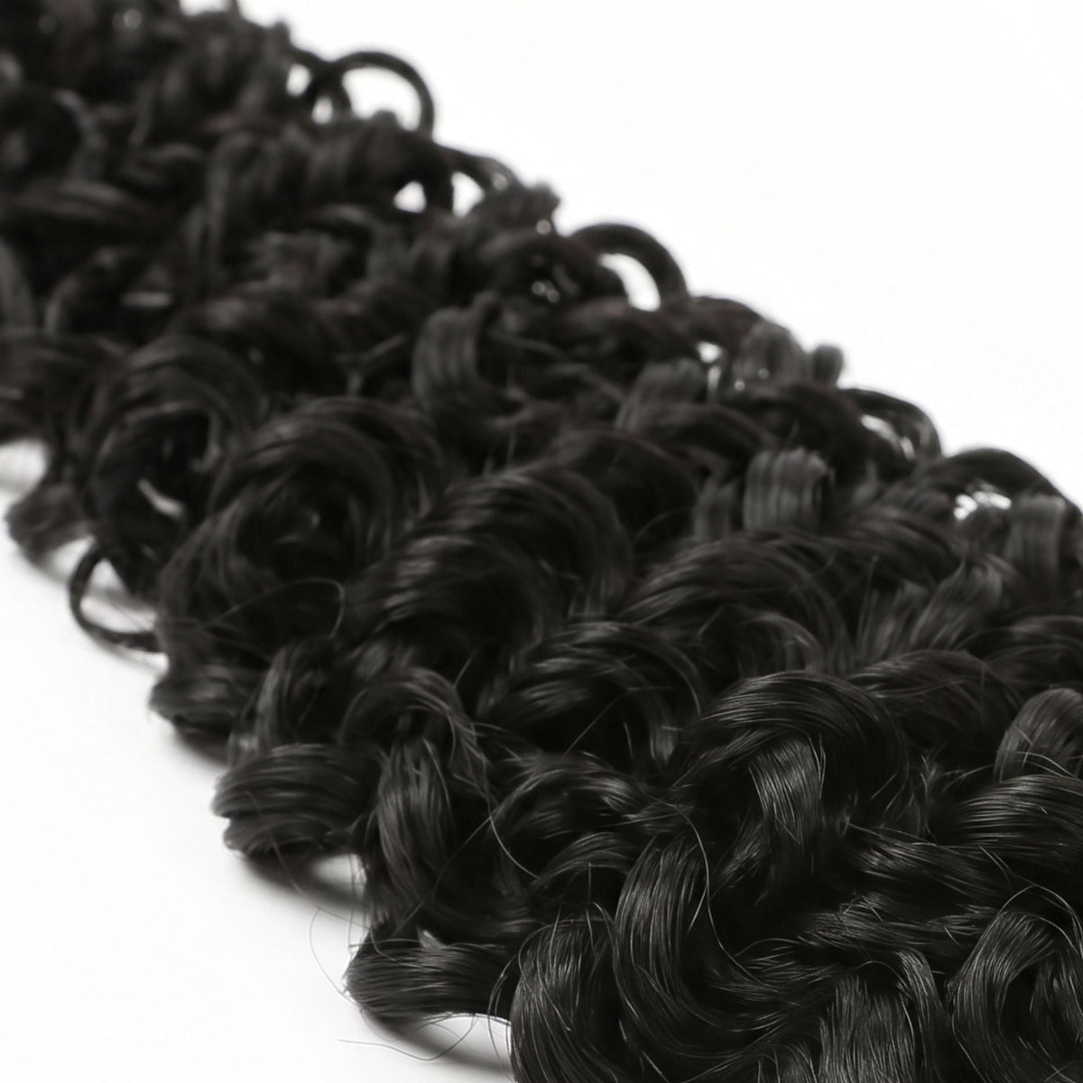 Macro close-up of the tight ocean wave curl pattern on natural black crochet hair extensions