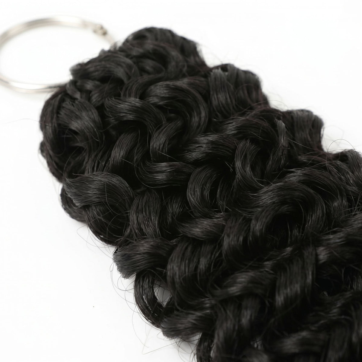 Angled close-up of the looped crochet strands and metal ring on natural black ocean wave hair extensions